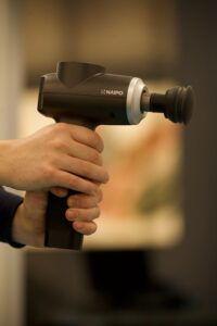 Person holding massage gun in hand